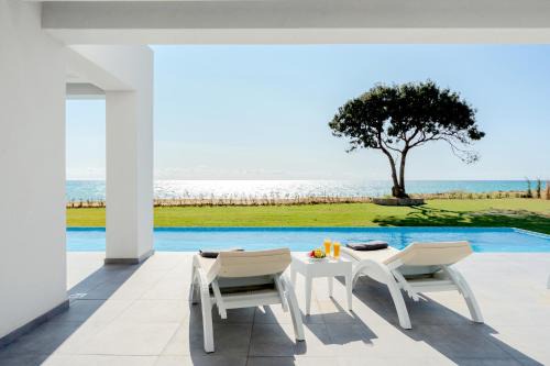 Chalikounas Villa | Seafront Villa Nafsika - Private Heated infinity Pool - Direct access to the beach - Play area