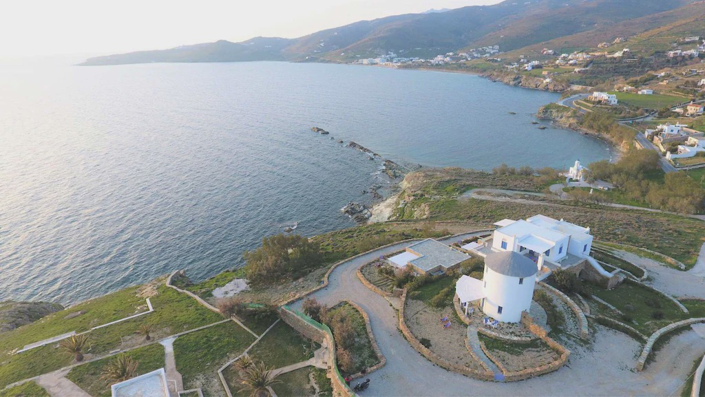 Tinos Town House | Windmill and houses by the sea / Stavros Bay