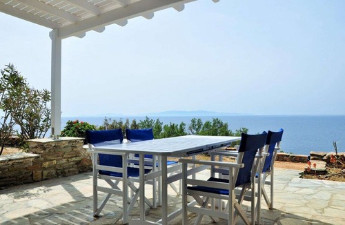 Tinos Town House | Windmill and houses by the sea / Stavros Bay