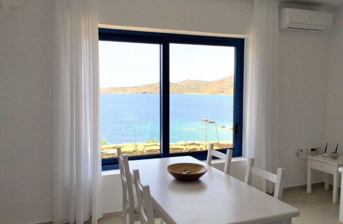 Tinos Town House | Windmill and houses by the sea / Stavros Bay